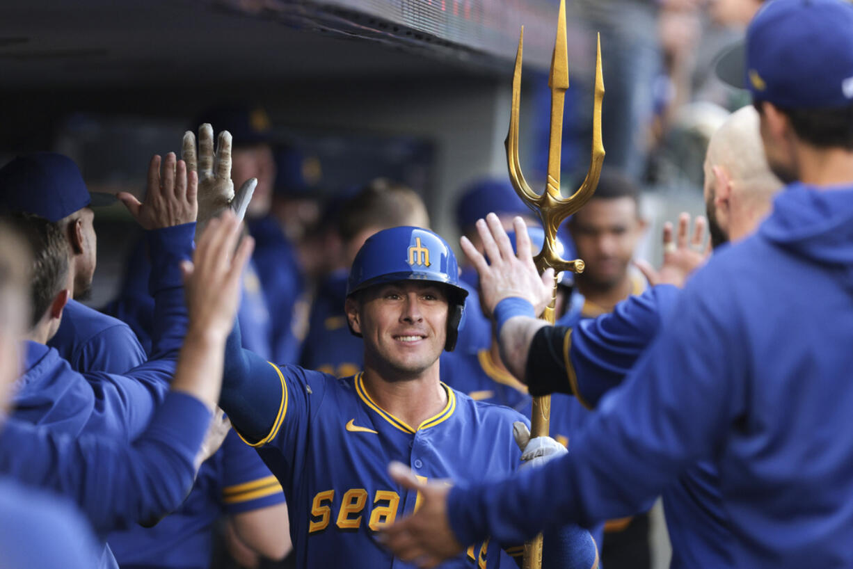Seattle Mariners' Dylan Moore celebrates in the dugout after his two-run home run during the fourth inning of a baseball game against the Oakland Athletics, Friday, May 10, 2024, in Seattle.
