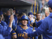 Seattle Mariners' Dylan Moore celebrates in the dugout after his two-run home run during the fourth inning of a baseball game against the Oakland Athletics, Friday, May 10, 2024, in Seattle.