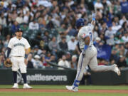 Kansas City Royals' Nelson Velazquez, right, runs the bases after hitting a three-run home run, while Seattle Mariners third baseman Luis Urias watches during the seventh inning of a baseball game Tuesday, May 14, 2024, in Seattle.