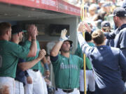Seattle Mariners' Ty France, center, holds a trident in the dugout after his solo home run during against the Kansas City Royals during the fourth inning of a baseball game Wednesday, May 15, 2024, in Seattle.