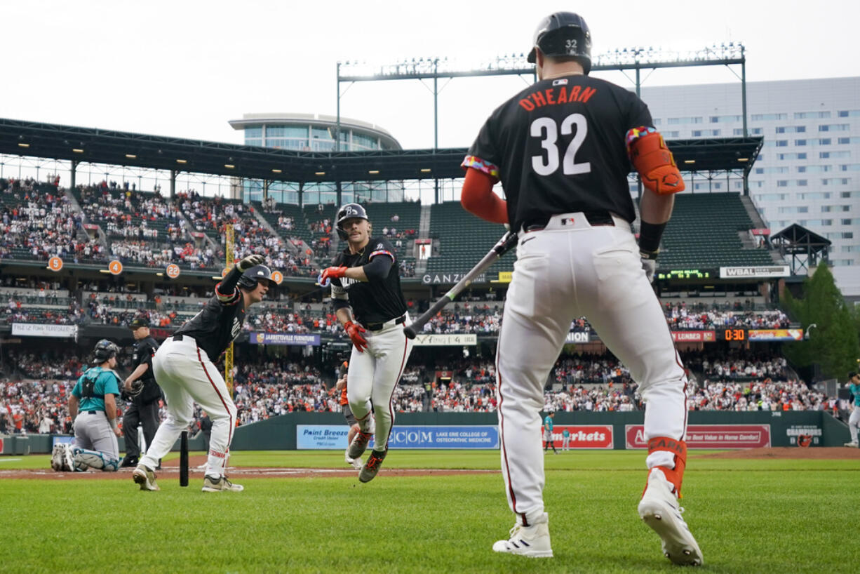 Baltimore Orioles' Gunnar Henderson, center, celebrates with Adley Rutschman, left, and Ryan O'Hearn (32) after hitting a home run against the Seattle Mariners during the first inning of a baseball game Friday, May 17, 2024, in Baltimore.