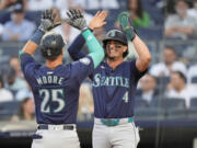 Seattle Mariners' Josh Rojas (4) celebrates with Dylan Moore (25) after Moore hit a two-run home run during the third inning of a baseball game against the New York Yankees, Tuesday, May 21, 2024, in New York.