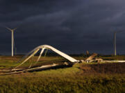 The remains of a tornado-damaged wind turbine touch the ground in a field, Tuesday, May 21, 2024, near Prescott, Iowa.