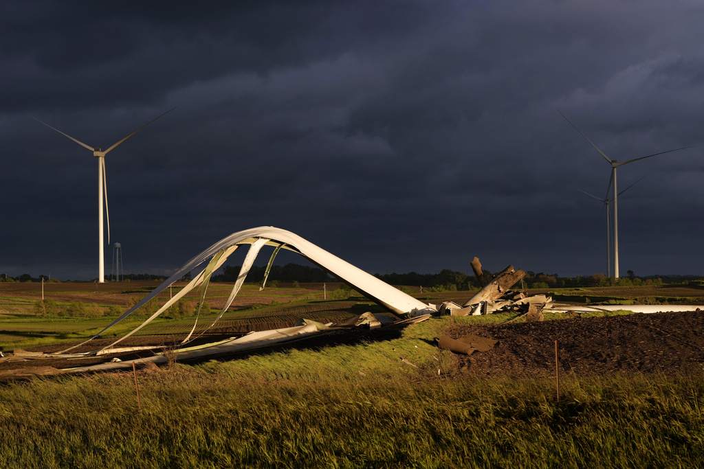 The remains of a tornado-damaged wind turbine touch the ground in a field, Tuesday, May 21, 2024, near Prescott, Iowa.