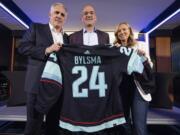 New Seattle Kraken NHL hockey team head coach Dan Bylsma is flanked by Kraken general manager Ron Francis and co-owner Samantha Holloway during an introductory press conference in Seattle, Tuesday, May 28, 2024.