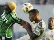 Austin FC forward Gyasi Zardes, left, and Portland Timbers defender Miguel Araujo, right, vie for control of the ball during the first half of an MLS soccer match in Austin, Texas, Wednesday, May 29, 2024.