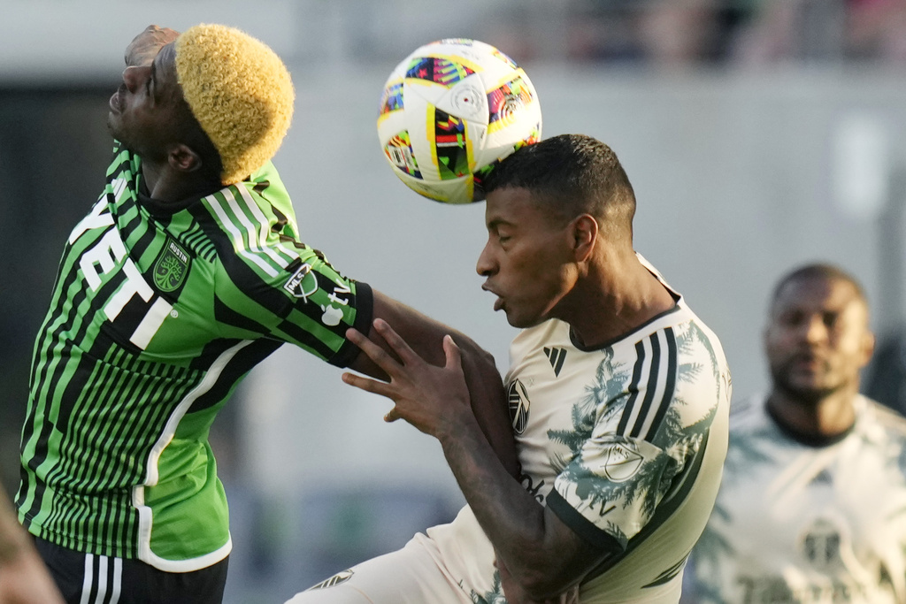 Austin FC forward Gyasi Zardes, left, and Portland Timbers defender Miguel Araujo, right, vie for control of the ball during the first half of an MLS soccer match in Austin, Texas, Wednesday, May 29, 2024.