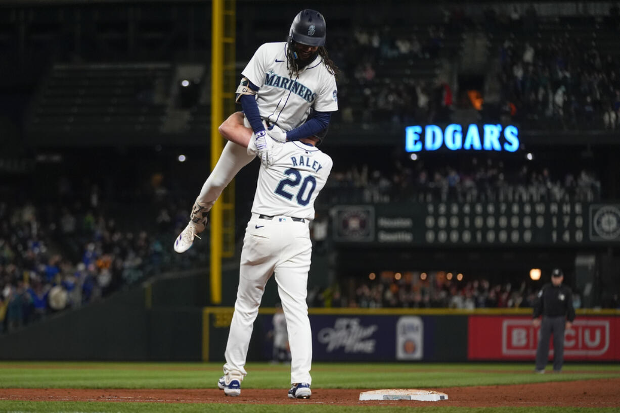 Seattle Mariners' J.P. Crawford is lifted by Luke Raley (20) after driving in the winning run with sacrifice fly against the Houston Astros during the 10th inning of a baseball game Wednesday, May 29, 2024, in Seattle. The Mariners won 2-1.