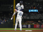 Seattle Mariners' J.P. Crawford is lifted by Luke Raley (20) after driving in the winning run with sacrifice fly against the Houston Astros during the 10th inning of a baseball game Wednesday, May 29, 2024, in Seattle. The Mariners won 2-1.