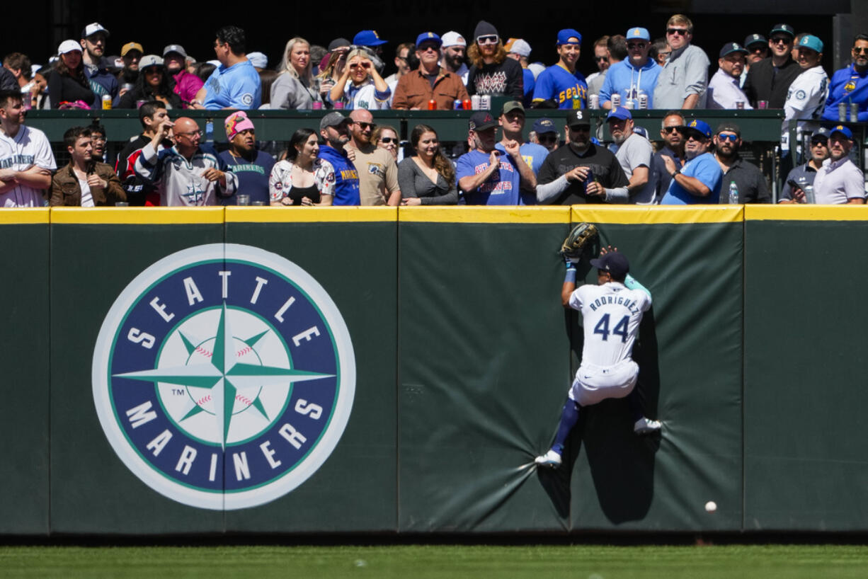 Seattle Mariners center fielder Julio Rodríguez can't catch a long fly ball hit by Houston Astros' Alex Bregman for a triple during the sixth inning of a baseball game, Thursday, May 30, 2024, in Seattle.