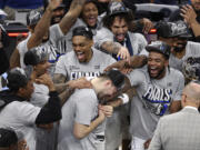 Dallas Mavericks guard Luka Doncic, center, celebrates with teammates after Game 5 of the Western Conference finals in the NBA basketball playoffs against the Minnesota Timberwolves, Thursday, May 30, 2024, in Minneapolis. The Mavericks won 124-103, taking the series 4-1 and moving on to the NBA Finals.