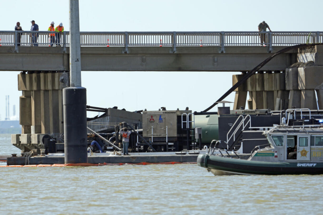 Workers survey the site where a barge crashed into the Pelican Island Bridge, Wednesday, May 15, 2024, in Galveston, Texas. (AP Photo/David J.