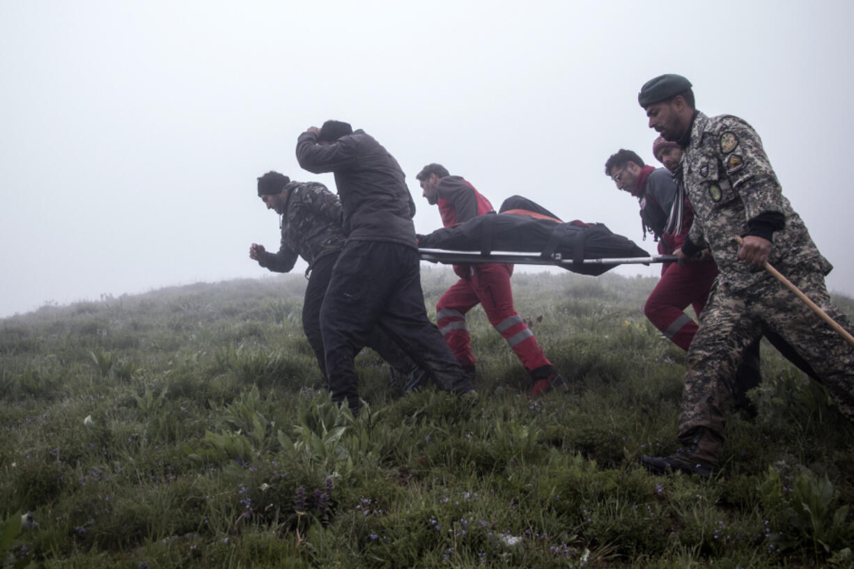 In this photo provided by Moj News Agency, rescue teams members carry the body of a victim after a helicopter carrying Iranian President Ebrahim Raisi crashed in Varzaghan, northwestern Iran, Monday, May 20, 2024. Iranian President Ebrahim Raisi, the country&rsquo;s foreign minister and others have been found dead at the site of a helicopter crash after an hours-long search through a foggy, mountainous region of the country&rsquo;s northwest, state media reported.