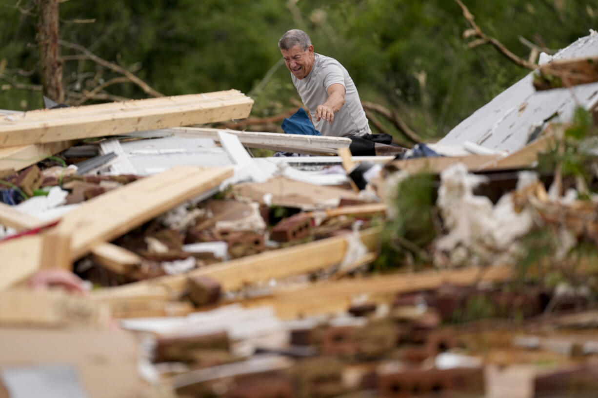 John Bernhardt picks up debris at his stormed damaged home Thursday, May 9, 2024, in Columbia, Tenn. A wave of dangerous storms began crashing over parts of the South on Thursday, a day after severe weather with damaging tornadoes killed several people in the region.