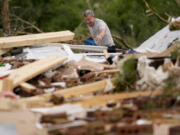 John Bernhardt picks up debris at his stormed damaged home Thursday, May 9, 2024, in Columbia, Tenn. A wave of dangerous storms began crashing over parts of the South on Thursday, a day after severe weather with damaging tornadoes killed several people in the region.