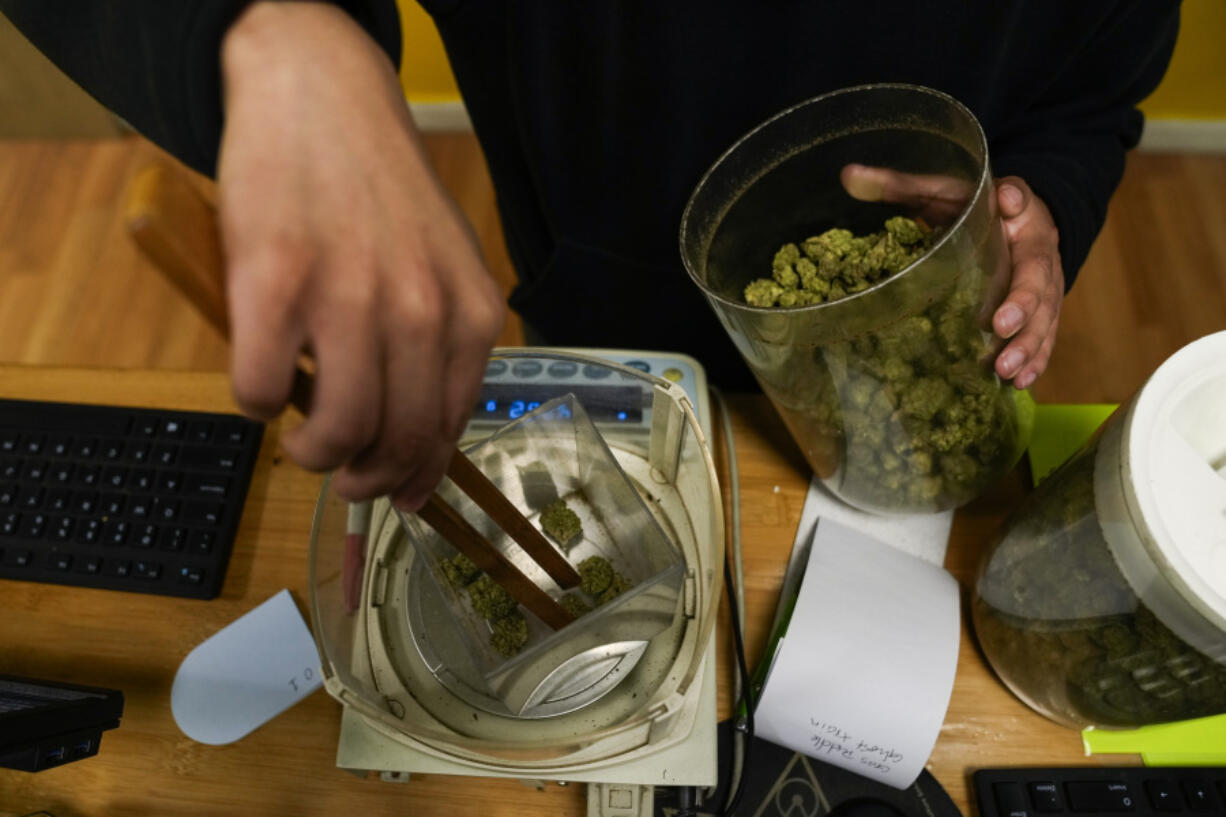 Budtender Rey Cruz weighs cannabis for a customer at the Marijuana Paradise on Friday, April 19, 2024, in Portland, Ore.