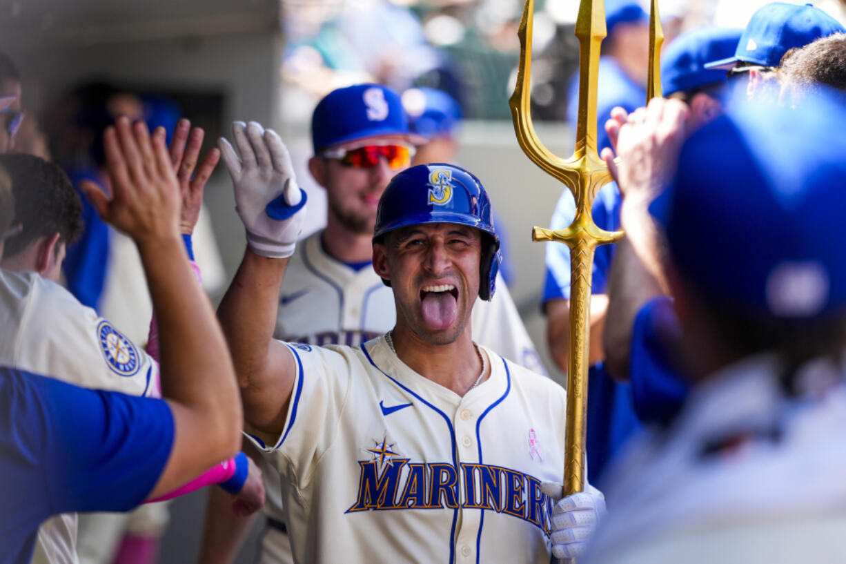 Seattle Mariners&#039; Seby Zavala sticks out his tongue as he holds a trident in the dugout while celebrating his solo home run against the Oakland Athletics during the sixth inning of a baseball game Sunday, May 12, 2024, in Seattle.