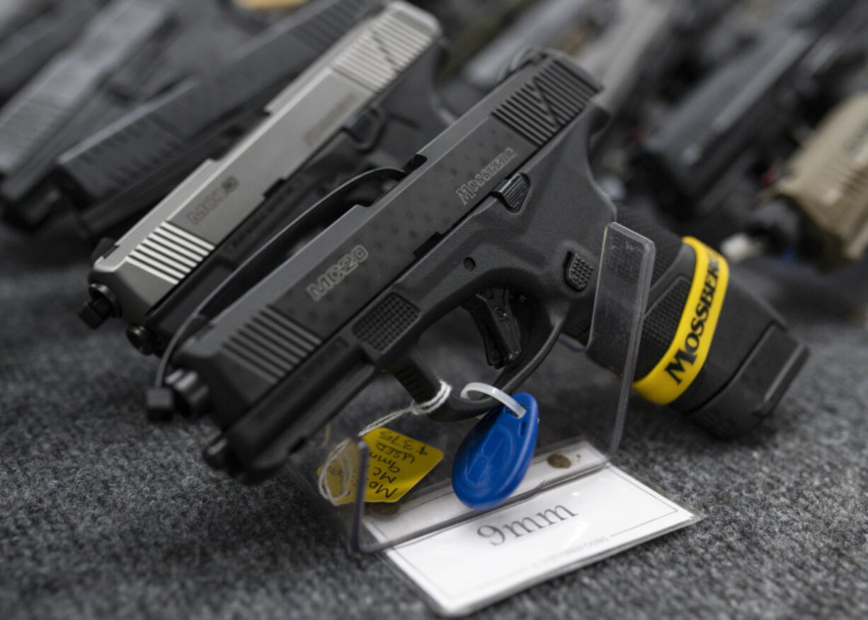 FILE - Pistols sit on display during the first day of the Silver Spur Gun and Blade Show, Jan. 22, 2022, in Odessa, Texas. On Monday, May 20, 2024, a federal judge blocked the Biden administration from enforcing a new rule in Texas that would require firearms dealers to run background checks on buyers at gun shows or other places outside brick-and-mortar stores.