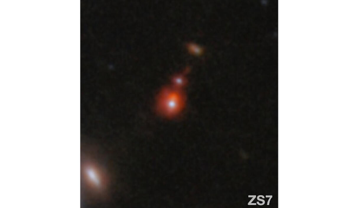 The ZS7 galaxy system, revealing the ionized hydrogen emission in orange and the doubly ionized oxygen emission in dark red.