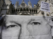 A poster of Julian Assange is left by protesters outside the High Court in London, Monday, May 20, 2024. A British court has ruled that WikiLeaks founder Julian Assange can appeal against an order that he be extradited to the U.S.