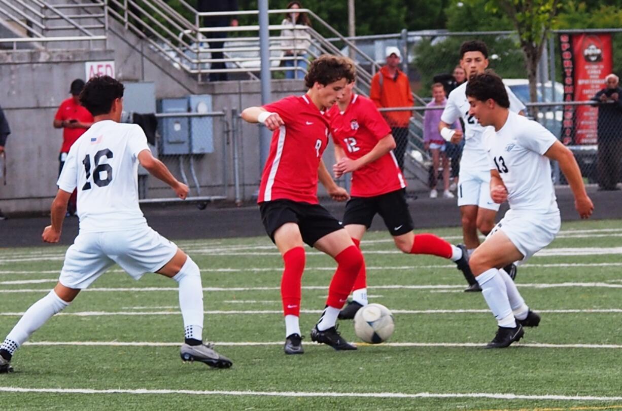 Camas sophomore Cooper Schneider (middle) takes the ball away from Chiawana midfielder Clayton Calderon (13) as Gustavo Escalera (16) closes in during the 4A state quarterfinal match Saturday, May 18, 2024, at Doc Harris Stadium in Camas.