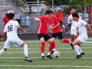 Camas sophomore Cooper Schneider (middle) takes the ball away from Chiawana midfielder Clayton Calderon (13) as Gustavo Escalera (16) closes in during the 4A state quarterfinal match Saturday, May 18, 2024, at Doc Harris Stadium in Camas.