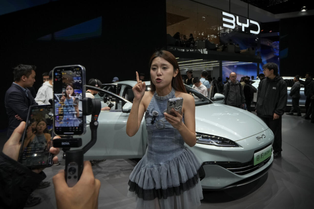 A model performs a live-streaming near a BYD Sea Leopard DM-i car model during the Auto China 2024 in Beijing, Sunday, April 28, 2024. Global automakers and EV startups unveiled new models and concept cars at China&rsquo;s largest auto show, with a focus on the nation&rsquo;s transformation into a major market and production base for digitally connected, new-energy vehicles.