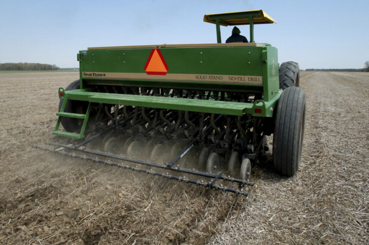 FILE - In this April 28, 2004, file photo Mearl McCartney plants soybeans using a no-till drill near Bowling Green, Ohio. In the world of greenhouse gas emissions, carbon dioxide gets most of the blame. But tiny organisms that flourish in the world&rsquo;s farm fields emit a far more potent gas, nitrous oxide, and scientists have long sought a way to address it. (AP Photo/J.D.