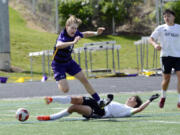 Columbia River's Alex Pont (9) falls to the turf after East Valley's Gavin Gordon (14) slides in for a tackle during the Class 2A boys soccer state quarterfinals on Saturday, May 18, 2024, at Columbia River High School.