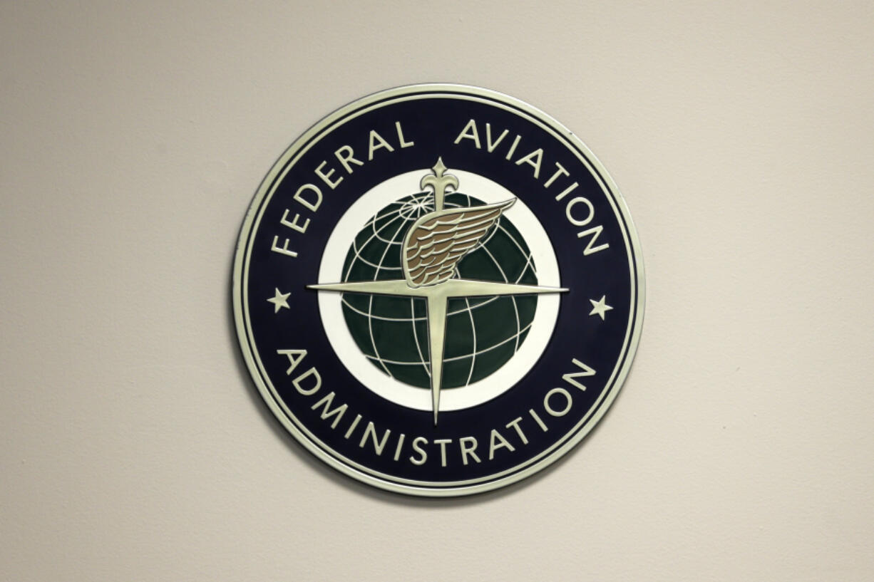 FILE - A Federal Aviation Administration sign hangs in the tower at John F. Kennedy International Airport in New York, March 16, 2017. Congressional negotiators have agreed on a $105 billion bill designed to improve the safety of air travel after a series of close calls between planes at the nation&rsquo;s airports.