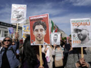 FILE - Protesters attend a rally against a death sentence given to a popular rapper in Iran and to support to the women of Iran, in Berlin, Germany, April 28, 2024. Lawmakers are introducing legislation targeting Iranian officials involved in the prosecution and planned execution of rapper Toomaj Salehi, who rose to fame with lyrics about the 2022 death of Mahsa Amini and for criticism of the Islamic Republic.