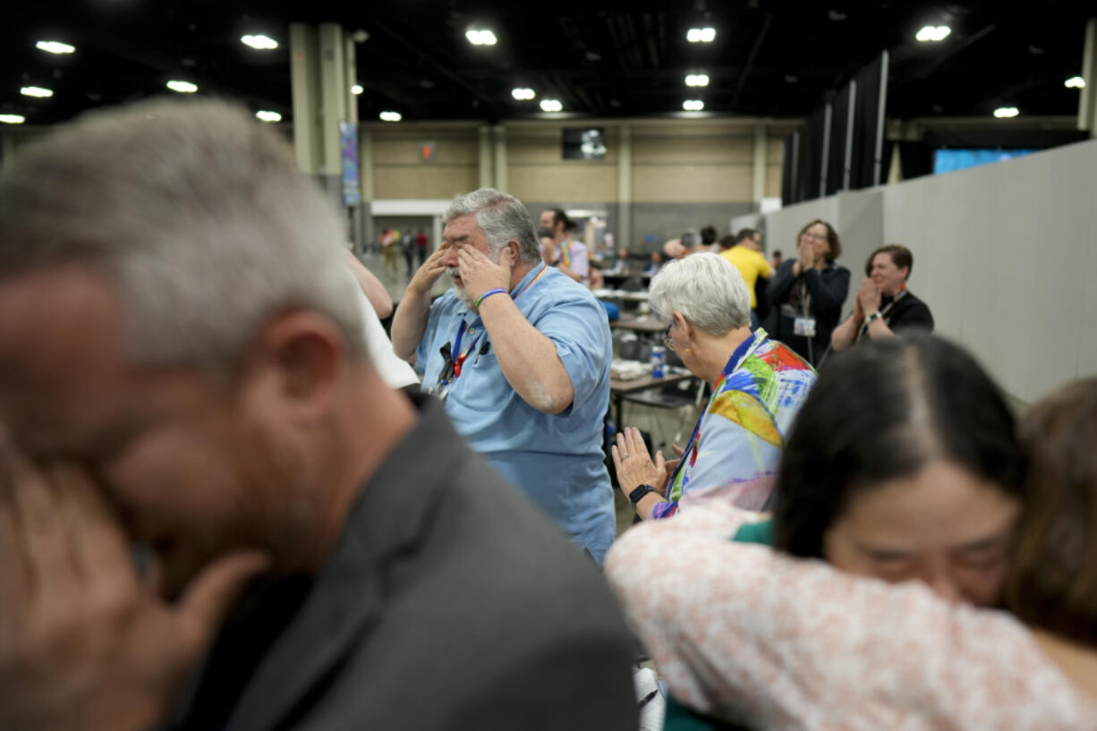 Rev. Andy Oliver, Pastor of Allendale UMC in St. Petersburg, Florida, left, David Meredith, center, and Jan Lawrence react after an approval vote at the United Methodist Church General Conference Wednesday, May 1, 2024, in Charlotte, N.C.  United Methodist delegates repealed their church&rsquo;s longstanding ban on LGBTQ clergy with no debate on Wednesday, removing a rule forbidding &ldquo;self-avowed practicing homosexuals&rdquo; from being ordained or appointed as ministers.