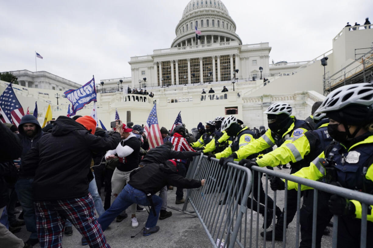FILE - Violent insurrectionists loyal to then-President Donald Trump try to break through a police barrier, Wednesday, Jan. 6, 2021, at the Capitol in Washington.