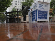 A person drops off a vote-by-mail ballot at a dropbox in Pioneer Square during primary voting on Tuesday in Portland.