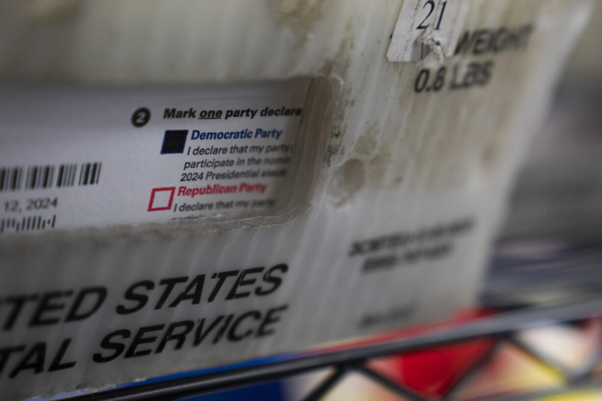 FILE - Vote-by-mail ballots for the presidential primary election are seen on March 12, 2024, at the Clark County Elections Office in Vancouver, Wash.
