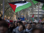 FILE - A boy waves a Palestinian flag as demonstrators march during a protest in support of Palestinians and calling for an immediate ceasefire in Gaza, in Barcelona, Spain, on Jan. 20, 2024. European Union countries Spain and Ireland as well as Norway on Wednesday announced dates for recognizing Palestine as a state.