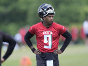 Atlanta Falcons first round draft pick quarterback Michael Penix Jr., takes a quick break during an NFL rookie minicamp football practice Friday, May 10, 2024, in Flowery Branch, Ga.