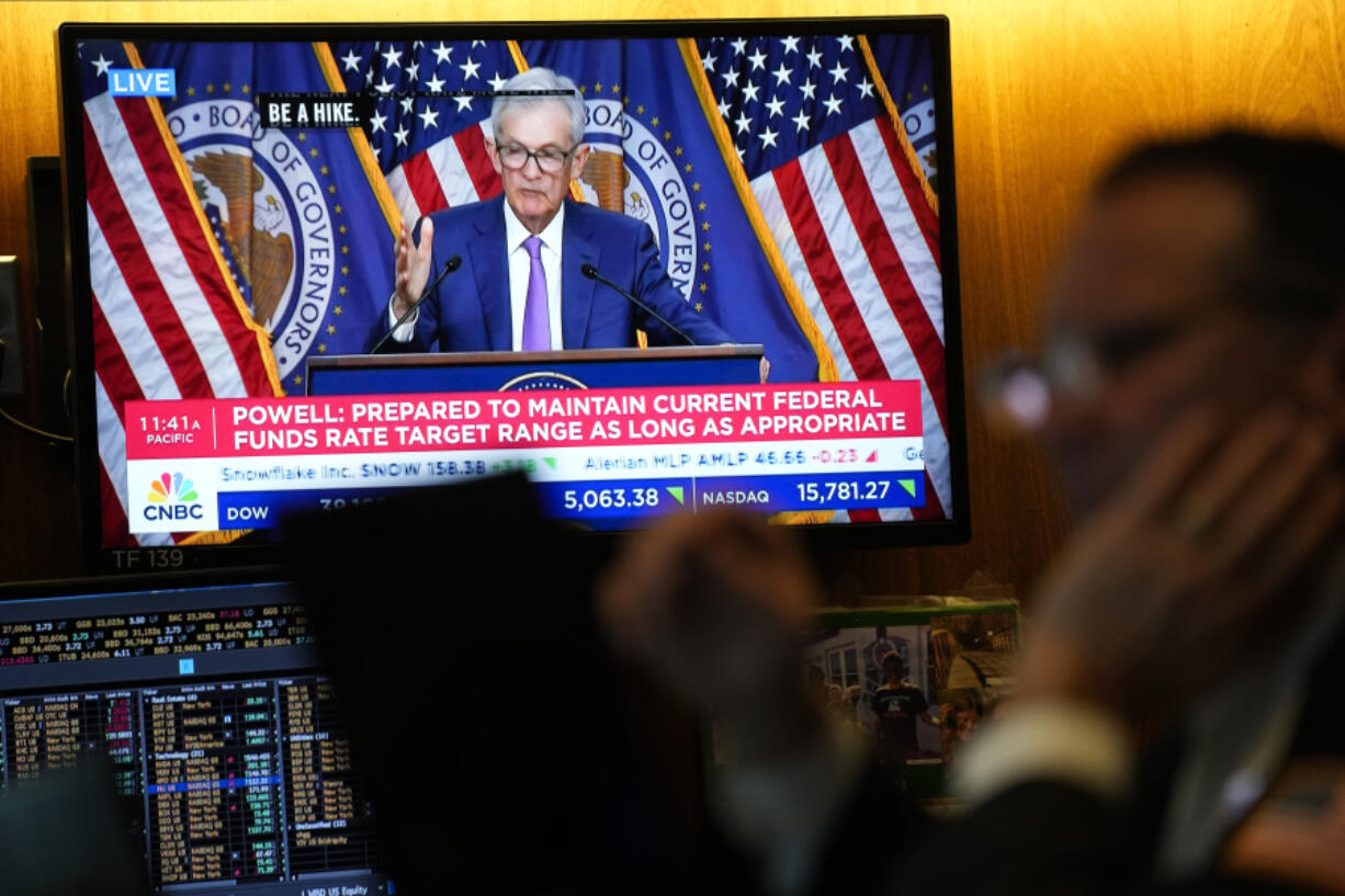 A screen displays a news conference with Federal Reserve Chairman Jerome Powell as traders work on the floor at the New York Stock Exchange in New York, Wednesday, May 1, 2024.