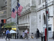 People pass the New York Stock Exchange on Wednesday, May 29, 2024, in New York. Wall Street was poised to open with losses as some major dealmaking and a handful of earnings reports fill the news void until Friday&rsquo;s latest inflation report.