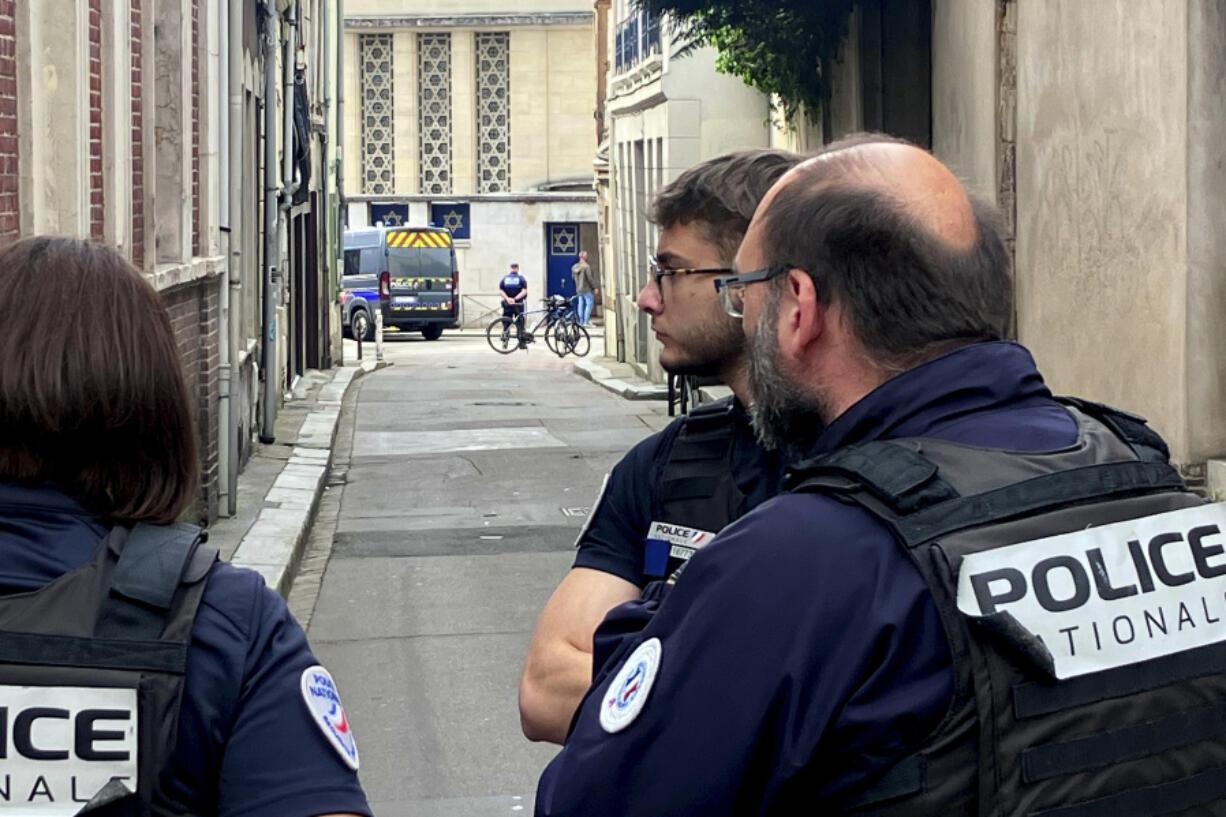 French policemen stand near the synagogue in Rouen, France, Friday, May 17, 2024. French police have shot and killed a man armed with a knife and a metal bar who is suspected of having set fire to a synagogue in the Normandy city of Rouen.
