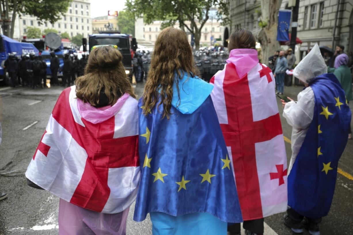 Demonstrators who wear Georgian national and EU flags stand in front of a police block during an opposition protest against &ldquo;the Russian law&rdquo; near the Parliament building in the center of Tbilisi, Georgia, Tuesday, May 14, 2024. The Georgian parliament on Tuesday approved in the third and final reading a divisive bill that sparked weeks of mass protests, with critics seeing it as a threat to democratic freedoms and the country&rsquo;s aspirations to join the European Union.