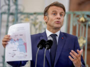 French President Emmanuel Macron shows a map during a press conference at the German government guest house in Meseberg, north of Berlin, Germany, Tuesday, May 28, 2024.