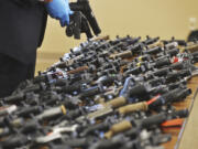 FILE - Dozens of recovered stolen handguns are displayed during a press conference, Nov. 21, 2023, in Benton Township, Mich. Two men, who are brothers, are accused of targeting a Dunham&rsquo;s near Benton Harbor. The rate of guns stolen from cars in the U.S. has tripled over the last decade, making them the largest source of stolen guns in the country, a new analysis of FBI data by the gun-safety group Everytown found.