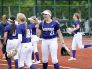 Heritage's Kylie Stroup (23) embraces teammate Gracie Peterson (18) as the Timberwolves walk off the field between innings of a Class 3A state softball opening round game against Mead on Thursday, May 23, 2024, at Regional Athletic Complex in Lacey.