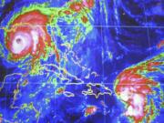 Hurricane Ivan is seen on the computer screen 250 miles from the Gulf Coast while Tropical Storm Jeanne approaches Puerto Rico on Sept. 15, 2004, at the National Hurricane Center in Miami. (J.