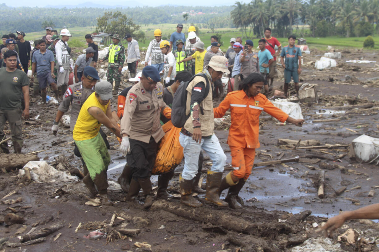 Rescuers carry the body of a victim of a flash flood in Tanah Datar, West Sumatra, Indonesia, Monday, May 13, 2024. Heavy rains and torrents of cold lava and mud flowing down a volcano&rsquo;s slopes on Indonesia&rsquo;s Sumatra island triggered flash floods causing a number of people dead and missing, officials said Sunday.