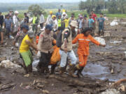 Rescuers carry the body of a victim of a flash flood in Tanah Datar, West Sumatra, Indonesia, Monday, May 13, 2024. Heavy rains and torrents of cold lava and mud flowing down a volcano&rsquo;s slopes on Indonesia&rsquo;s Sumatra island triggered flash floods causing a number of people dead and missing, officials said Sunday.