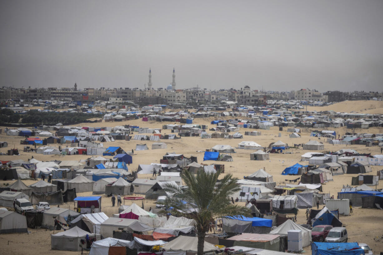 Palestinians displaced by the Israeli air and ground offensive on the Gaza Strip walk through a makeshift tent camp in Rafah, Gaza, Friday, May 10, 2024.