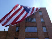 A giant American flag is unfurled on Lisner Hall on the campus of George Washington University in Washington, Friday, May 3, 2024, as demonstrators protest the Israel-Hamas war.