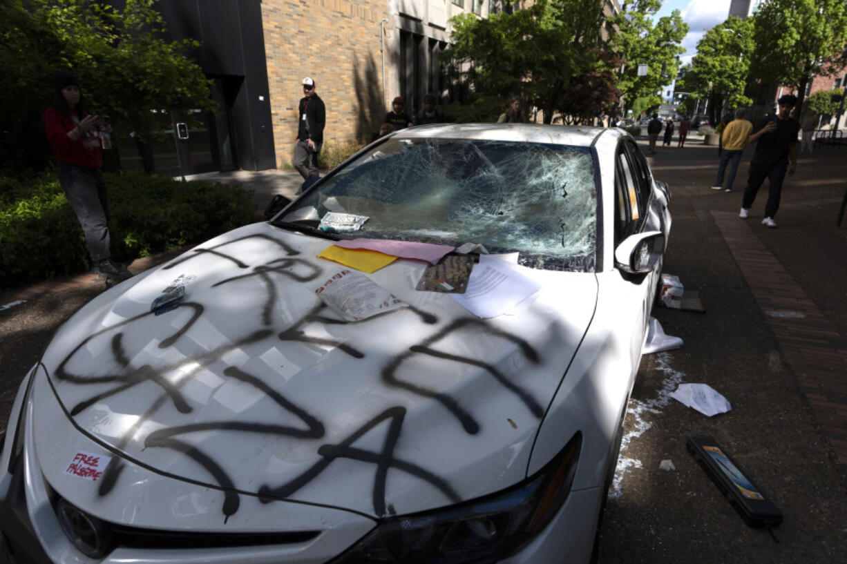 A car that attempted to drive through a crowd of pro-Palestinian protesters on the Portland State University campus is seen parked and damaged on a campus walkway on Thursday, May 2, 2024, in Portland, Ore. After the driver fled on foot the protesters damaged the car.